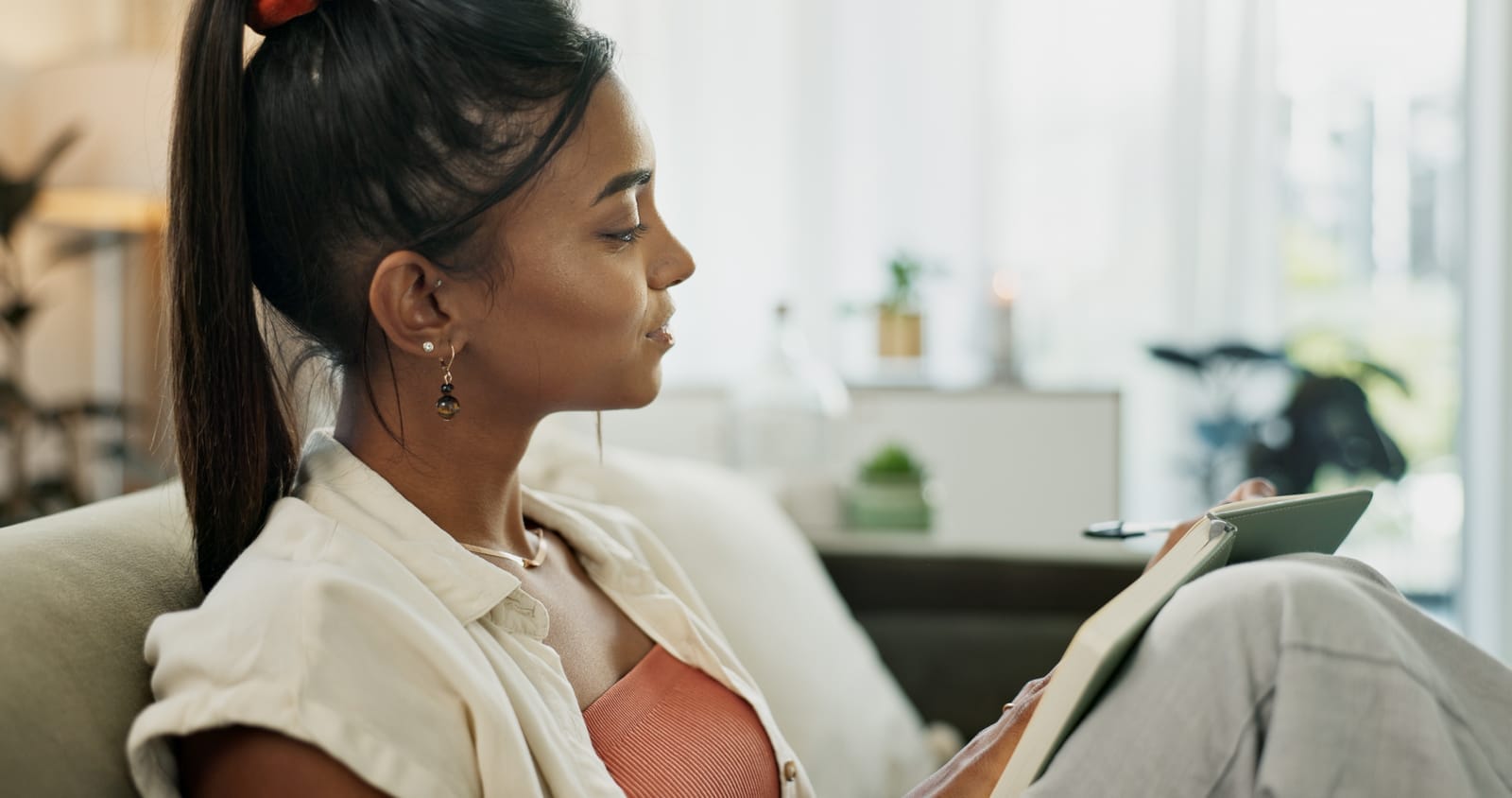 55476732_book-woman-and-writing-goals-for-future-planning-and-journal-for-self-care-goals-and-growth-happy-person-notebook-and-smiling-for-notes-agenda-and-inspirational-affirmations-on-couch-at-home.jpg