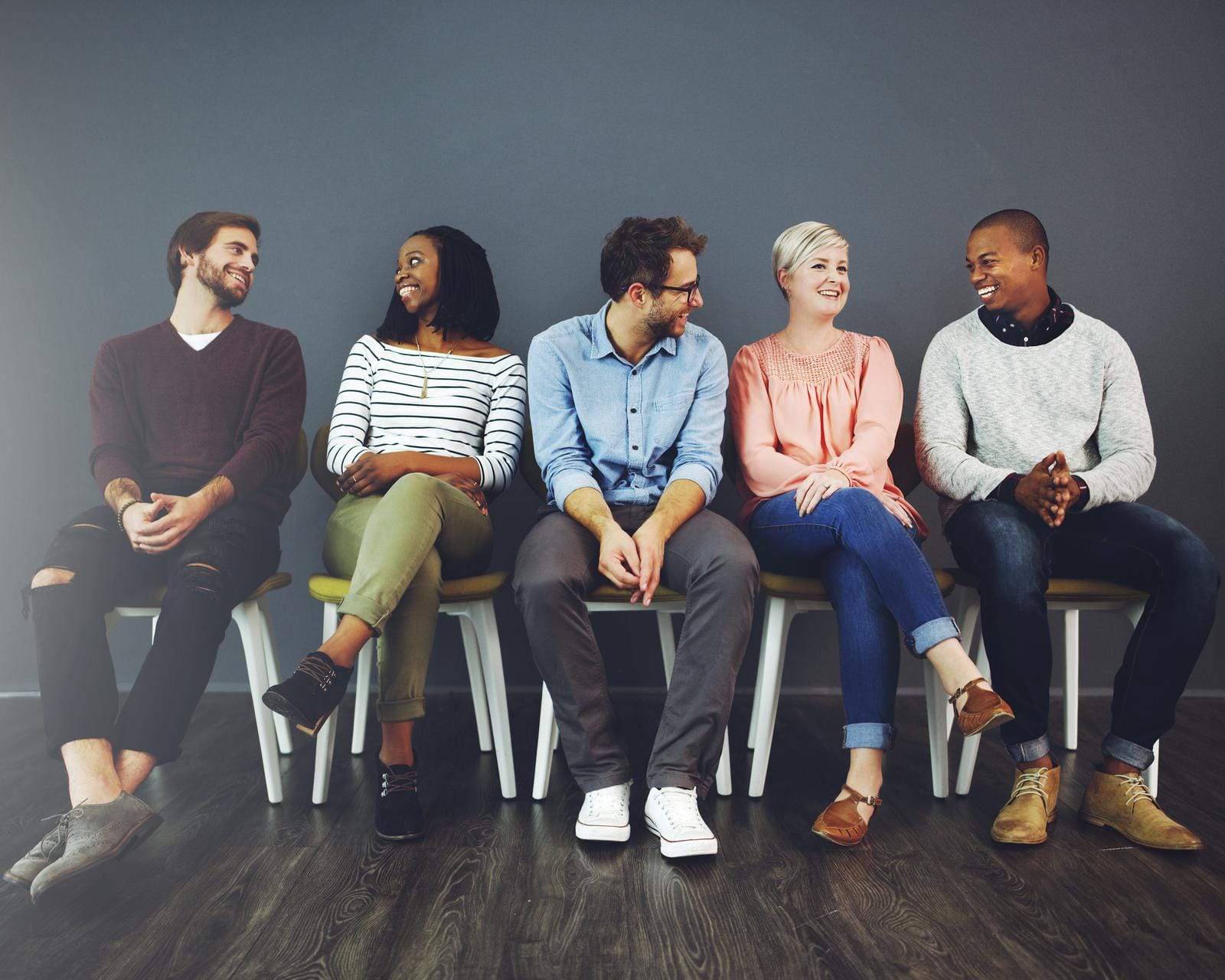 48229246_we-can-learn-lots-by-just-talking-to-each-other-studio-shot-of-a-group-of-young-people-waiting-in-line-on-chairs-and-chatting-against-a-gray-background.jpg